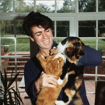 George Michael poses at home with his cat after losing his voice and being forced to cancel a number of live shows in 1980